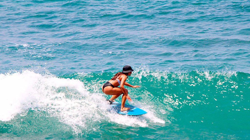 Surf Photographer High-quality action photograph of a female surfer successfully riding a pristine wave during a surf session in Nayarit.